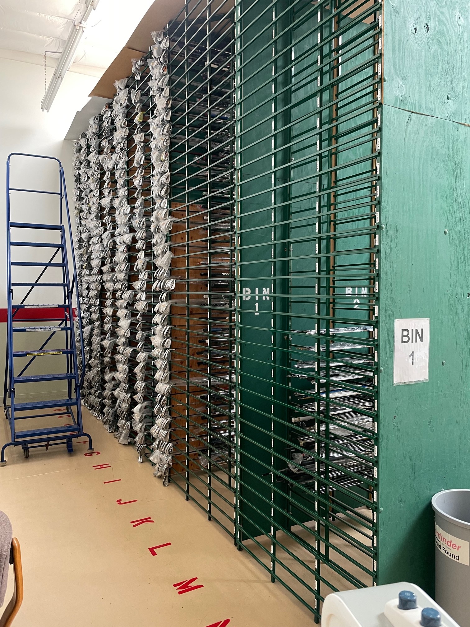 This aisle contains 5 Warehouse golf club racks connected together.